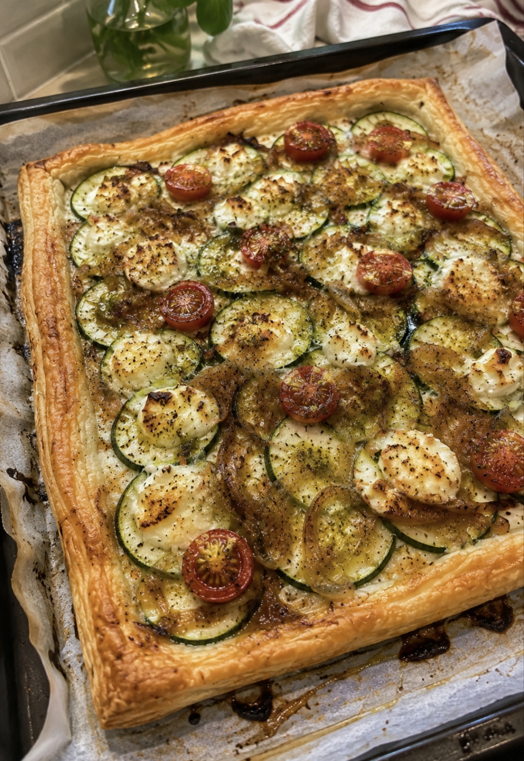 Hojaldre fino de calabacín, queso de cabra y cebolla caramelizada, con aceite de albahaca y un toque de miel